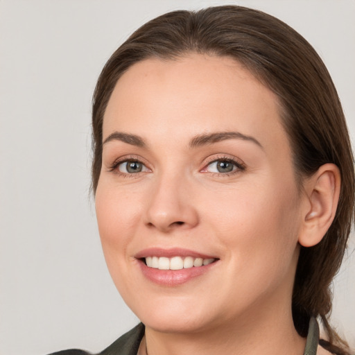 Joyful white young-adult female with long  brown hair and grey eyes