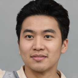 Joyful asian young-adult male with short  black hair and brown eyes