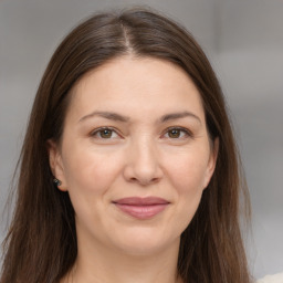 Joyful white adult female with long  brown hair and brown eyes