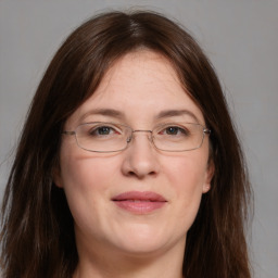 Joyful white adult female with long  brown hair and grey eyes