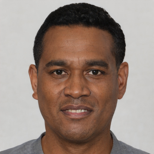 Joyful black young-adult male with short  black hair and brown eyes