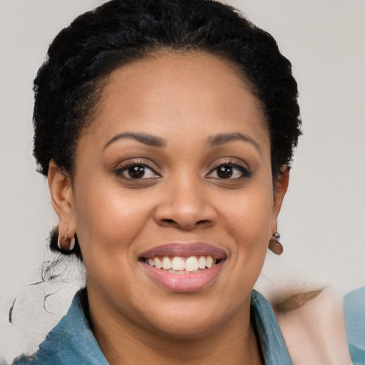 Joyful black young-adult female with short  black hair and brown eyes