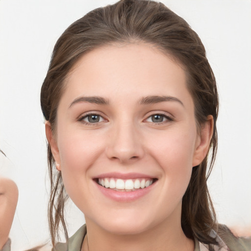 Joyful white young-adult female with medium  brown hair and grey eyes