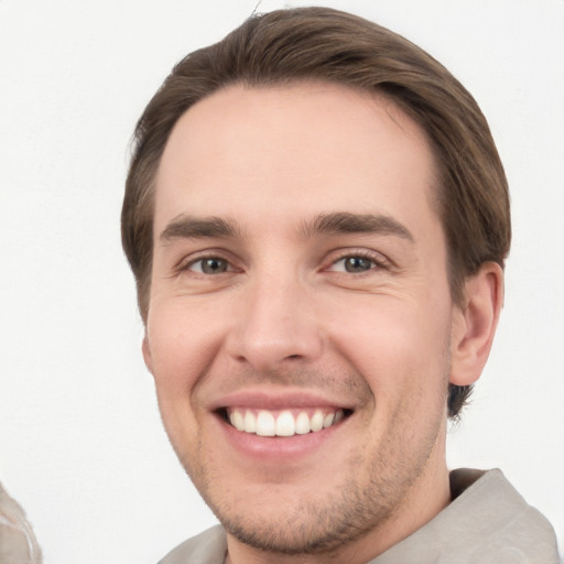 Joyful white young-adult male with short  brown hair and grey eyes