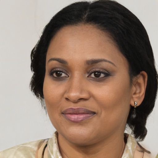 Joyful black adult female with medium  brown hair and brown eyes