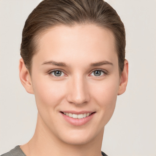 Joyful white young-adult female with short  brown hair and grey eyes