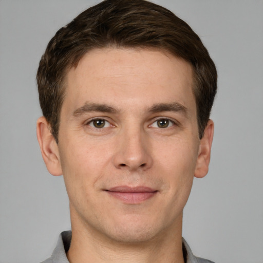 Joyful white young-adult male with short  brown hair and grey eyes