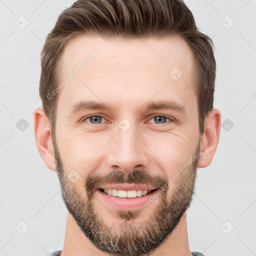 Joyful white young-adult male with short  brown hair and grey eyes