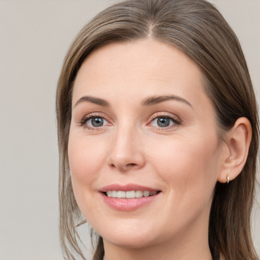 Joyful white young-adult female with long  brown hair and grey eyes