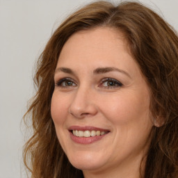 Joyful white adult female with long  brown hair and brown eyes