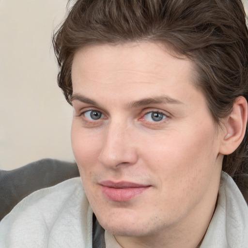 Joyful white young-adult male with medium  brown hair and grey eyes