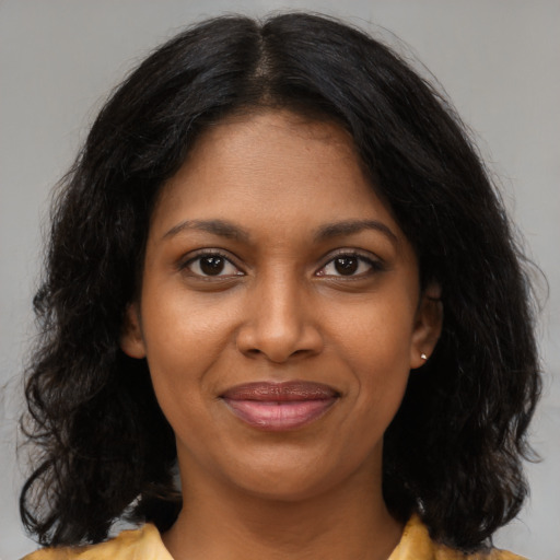 Joyful black young-adult female with medium  brown hair and brown eyes