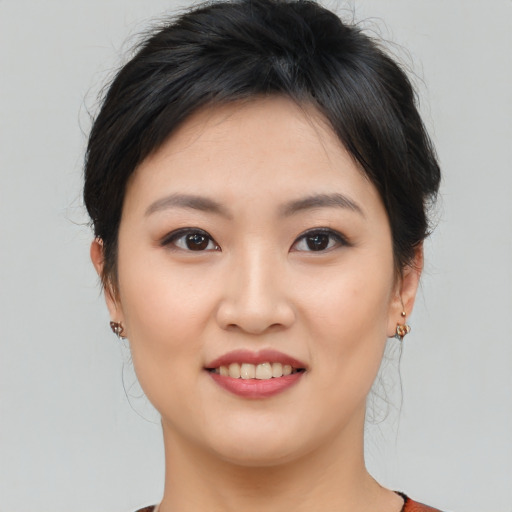 Joyful asian young-adult female with medium  brown hair and brown eyes