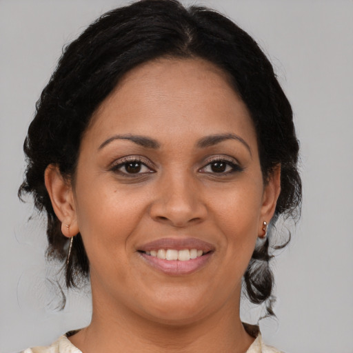 Joyful latino adult female with medium  brown hair and brown eyes