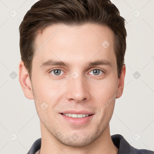 Joyful white young-adult male with short  brown hair and grey eyes