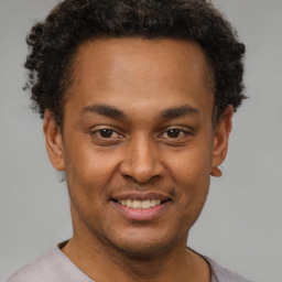 Joyful latino young-adult male with short  brown hair and brown eyes