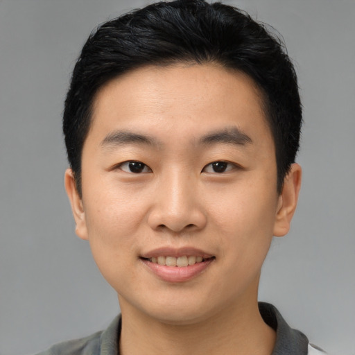 Joyful asian young-adult male with short  black hair and brown eyes
