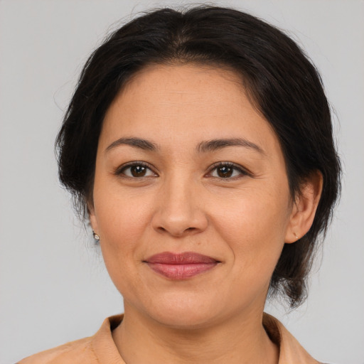 Joyful asian adult female with medium  brown hair and brown eyes