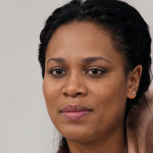 Joyful black adult female with long  black hair and brown eyes