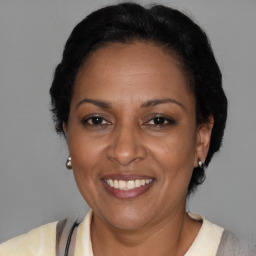 Joyful black adult female with medium  brown hair and brown eyes