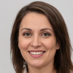 Joyful white adult female with long  brown hair and brown eyes