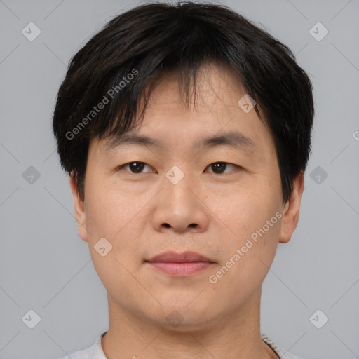 Joyful asian young-adult male with short  brown hair and brown eyes