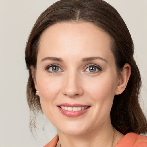 Joyful white young-adult female with long  brown hair and grey eyes