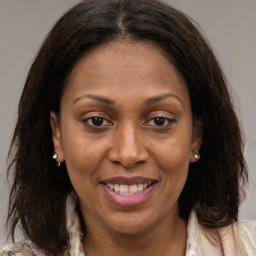 Joyful black adult female with medium  brown hair and brown eyes