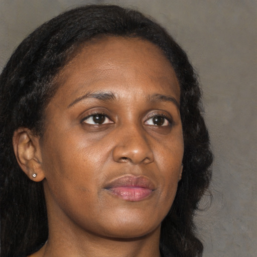 Joyful black adult female with long  brown hair and brown eyes