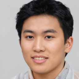 Joyful asian young-adult male with short  black hair and brown eyes