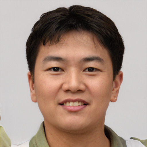 Joyful asian young-adult male with short  brown hair and brown eyes