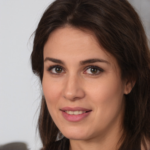 Joyful white young-adult female with long  brown hair and brown eyes