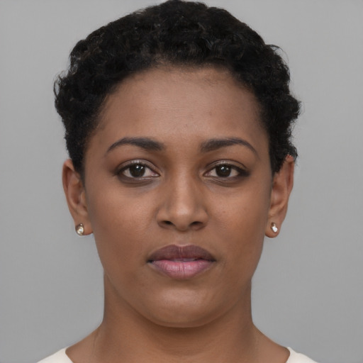 Joyful black young-adult female with short  black hair and brown eyes