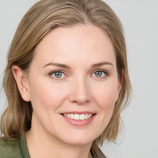 Joyful white young-adult female with medium  brown hair and blue eyes