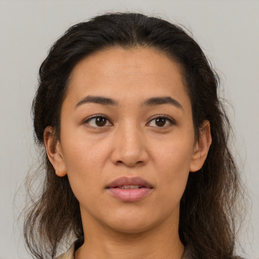 Joyful latino young-adult female with long  brown hair and brown eyes