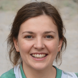 Joyful white young-adult female with medium  brown hair and grey eyes