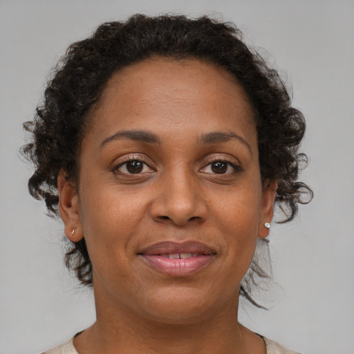 Joyful black adult female with medium  brown hair and brown eyes