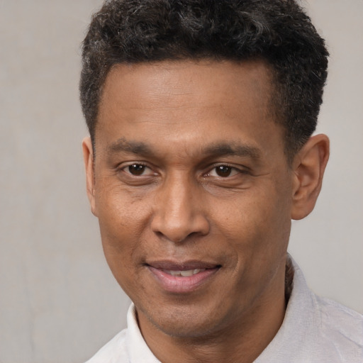 Joyful latino adult male with short  black hair and brown eyes