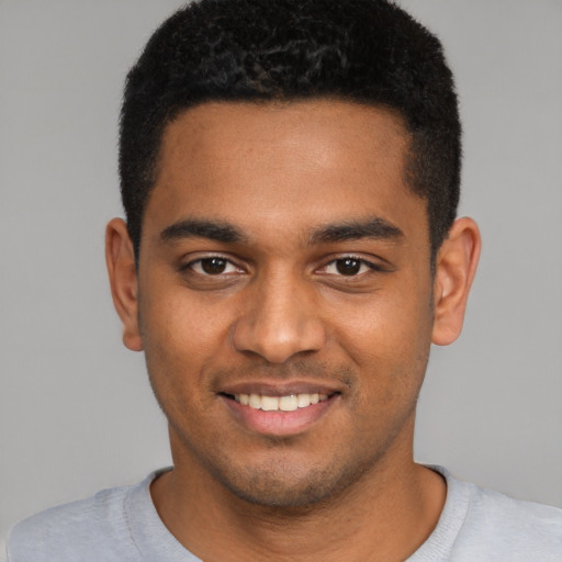 Joyful black young-adult male with short  brown hair and brown eyes