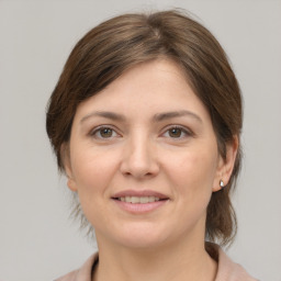 Joyful white young-adult female with medium  brown hair and grey eyes