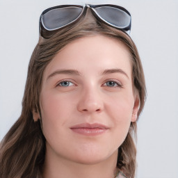 Joyful white young-adult female with long  brown hair and blue eyes