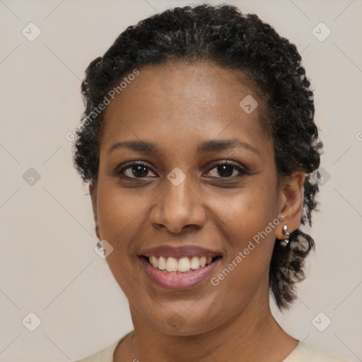 Joyful black young-adult female with short  brown hair and brown eyes