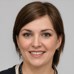 Joyful white young-adult female with medium  brown hair and grey eyes