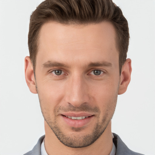 Joyful white young-adult male with short  brown hair and grey eyes