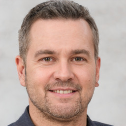 Joyful white adult male with short  brown hair and brown eyes