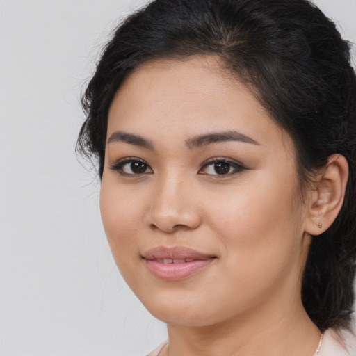 Joyful latino young-adult female with medium  brown hair and brown eyes