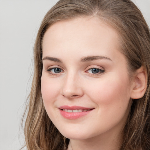 Joyful white young-adult female with long  brown hair and blue eyes