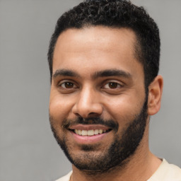 Joyful black young-adult male with short  black hair and brown eyes