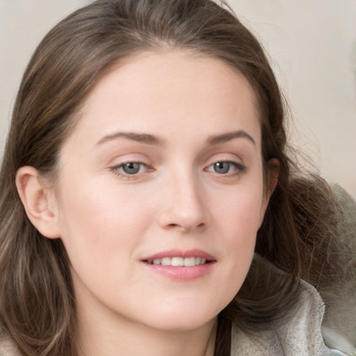 Joyful white young-adult female with long  brown hair and grey eyes