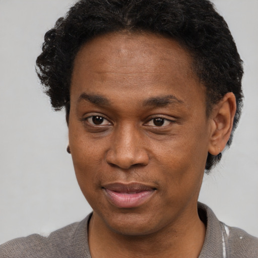 Joyful black young-adult male with short  brown hair and brown eyes
